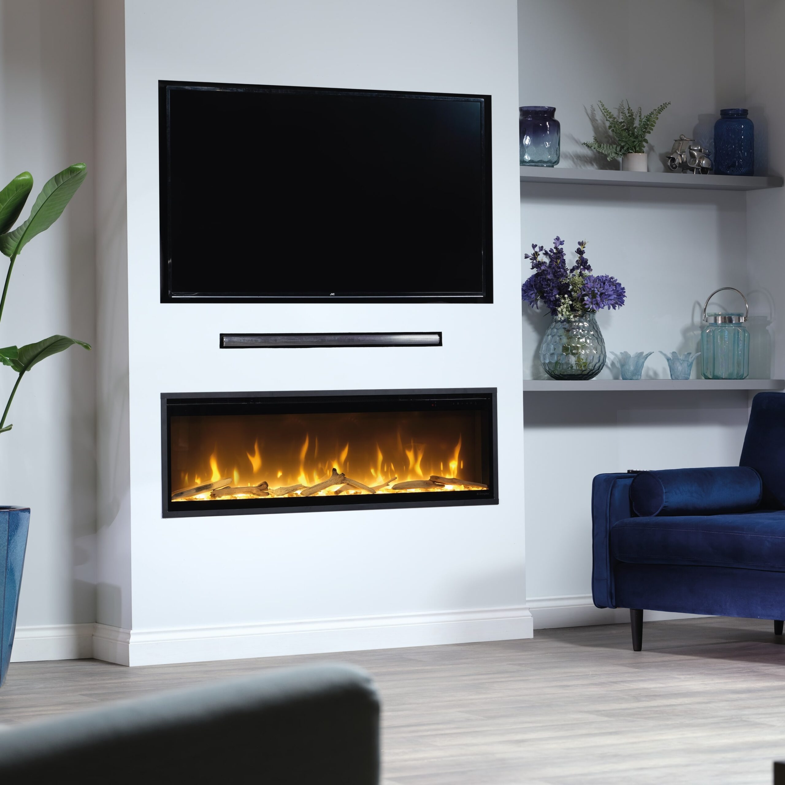 Altia Plus Electric Fireplace by GlammFire in a living room with blue-toned decor, featuring an LCD display and heating function.