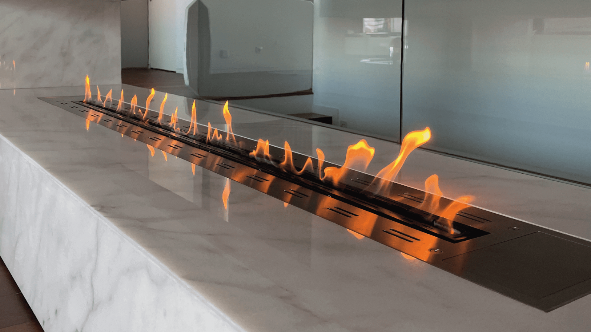 Fire Line bioethanol burner by GlammFire integrated into a modern marble fireplace