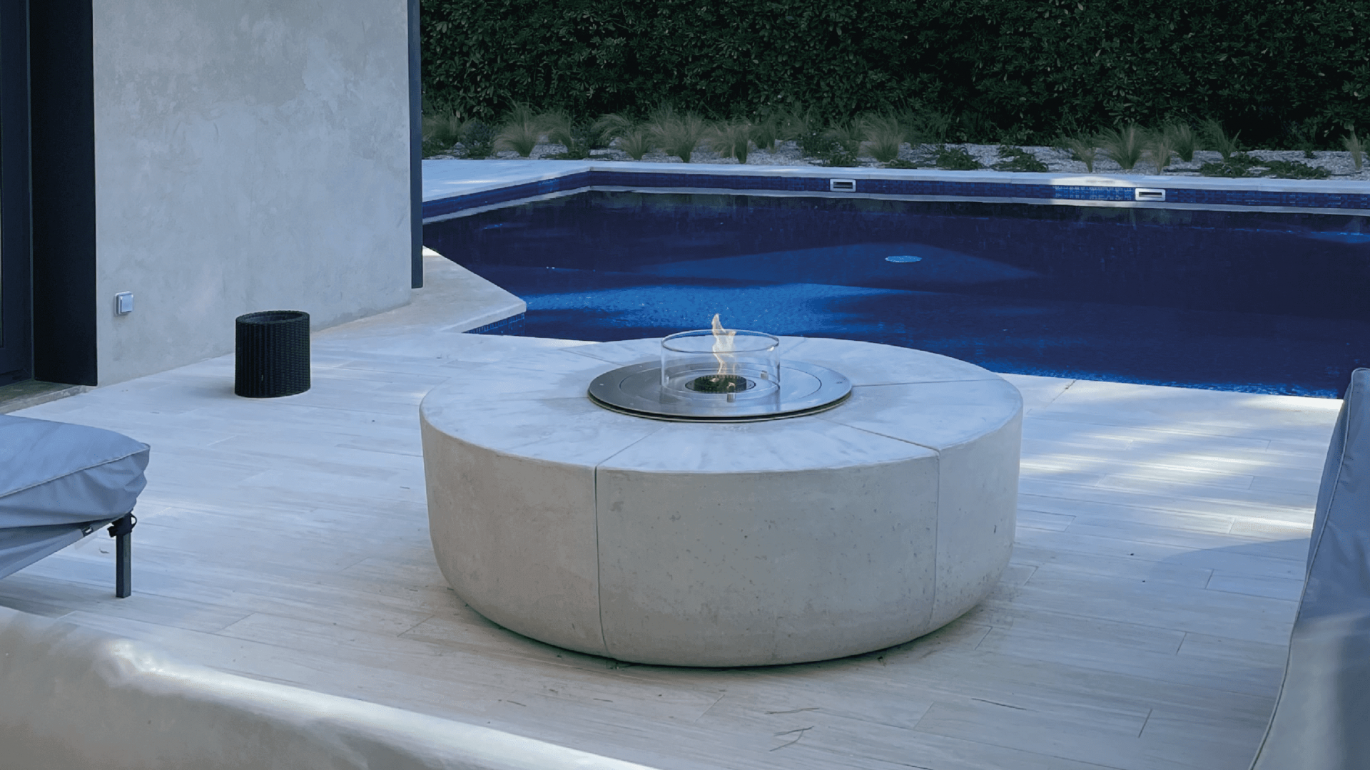 Modern bioethanol fire pit by GlammFire next to a swimming pool in a contemporary outdoor space